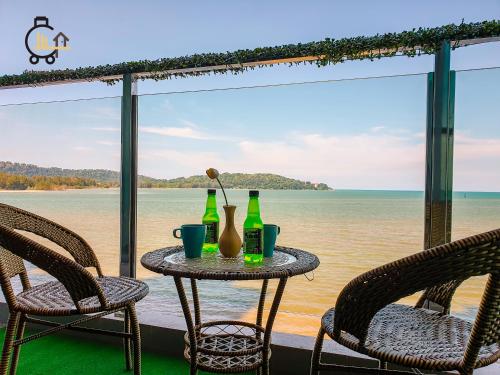 a table with two chairs and two bottles on it at 1 min to Seaview & Sunrise Heart of Kuantan in Kuantan
