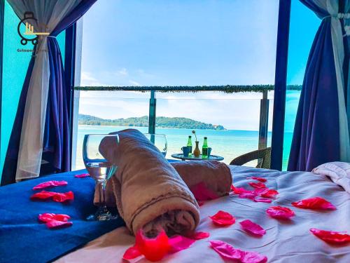 a bed with flowers on it with a view of the ocean at 1 min to Seaview & Sunrise Heart of Kuantan in Kuantan