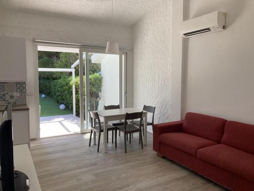 een woonkamer met een rode bank en een tafel en stoelen bij Villetta cod. 454 Taunus Vacanze in Numana