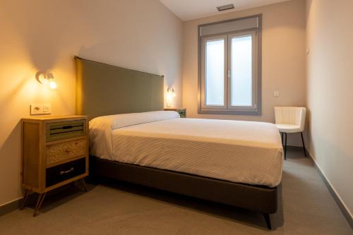 1 dormitorio con 1 cama, vestidor y ventana en A Oliveira, en Vilaboa