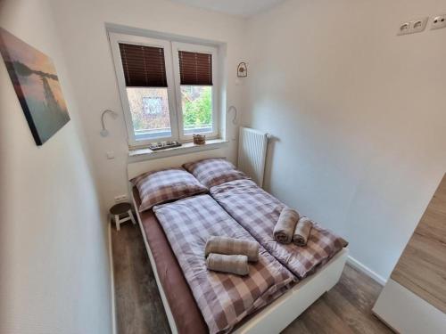 um quarto com uma cama com um cobertor xadrez em Appartementhaus-Kogge-Wohnung-5 em Cuxhaven
