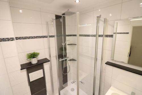 uma casa de banho com um chuveiro e uma porta de vidro em Appartementhaus-Kogge-Wohnung-5 em Cuxhaven