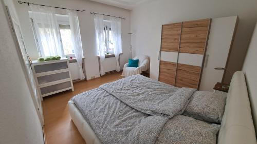 a bedroom with a bed and a dresser and windows at Haus Piroschka in Mörbisch am See
