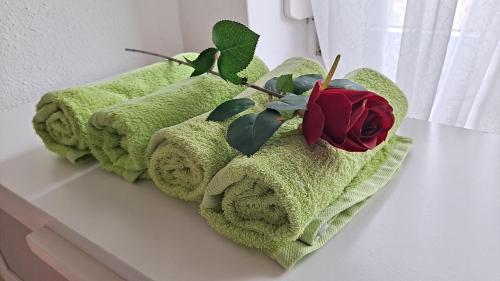 a couple of towels sitting on a shelf with a rose at Haus Piroschka in Mörbisch am See