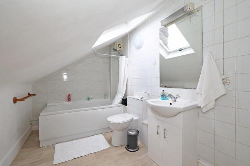 a white bathroom with a toilet and a sink at Magnificent Maida Vale 1bd apt for 3 in London