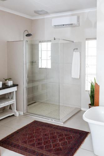 a bathroom with a shower with a glass door at Naftali Guest Farm in Kanoneiland