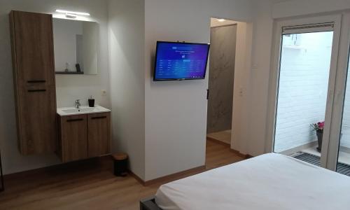 1 dormitorio con TV de pantalla plana en la pared en LoftBeach, en Koksijde