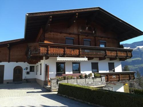 a large wooden house with a balcony at Ferienwohnung Familie Fiechtl in Fügenberg