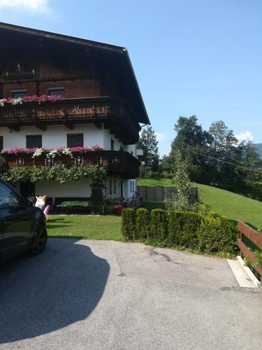 a car parked in front of a house with flowers at Ferienwohnung Familie Fiechtl in Fügenberg