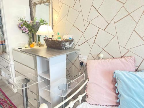 um quarto com uma mesa, um espelho e uma cama em Daisy Blossom Studio em Bromley