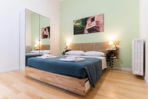 1 Schlafzimmer mit 2 Betten und einem großen Spiegel in der Unterkunft Residenza Leoncino in Verona