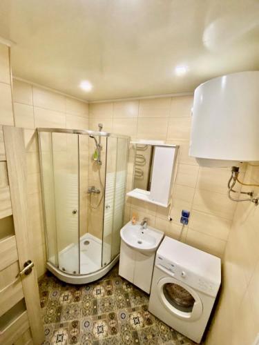 a bathroom with a shower toilet and a sink at Апартаменти на Поштовій площі in Kyiv