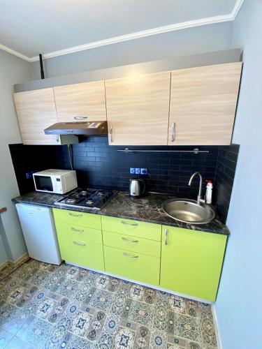a kitchen with green cabinets and a sink at Апартаменти на Поштовій площі in Kyiv