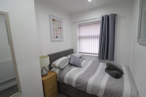 a bedroom with a bed and a window at Cosy two bedroom first floor apartment in Birmingham