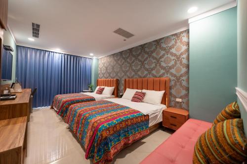 a bedroom with a bed and a desk and a bed sidx sidx sidx at 波西塔諾villa民宿 全新旅店市中心 歐式別墅 親子住宿 in Xiaoliuqiu