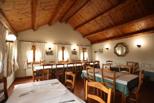 comedor con mesas y sillas y techos de madera en Hotel de Montaña Lamiana, en Lamiana