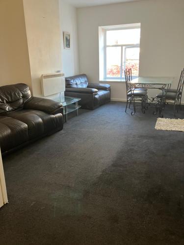 a living room with a couch and a table at Entire central apartment which sleeps up to 6 in Ramsbottom