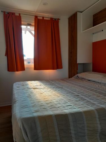 a bedroom with a large bed with red curtains at Agricampeggio Le Corniole in Affi