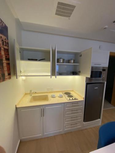 a small kitchen with a sink and a stove at Hasanah suites in Al Madinah