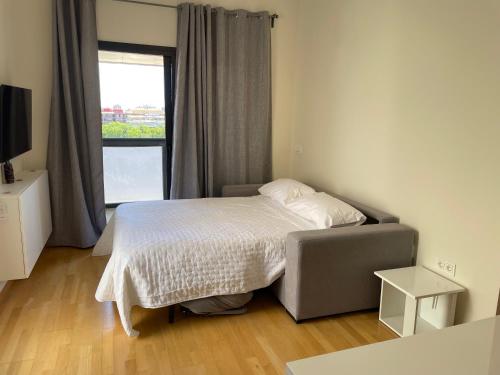 Habitación pequeña con cama y ventana en Apartamento Vips Suites, en Murcia