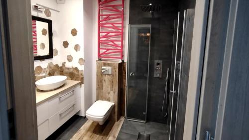 a bathroom with a shower and a toilet and a sink at Apartament w lesie nad rzeką in Dywity