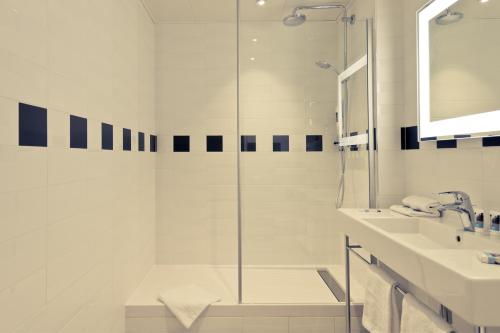 a white bathroom with a shower and a sink at Mercure Nice Marché Aux Fleurs in Nice