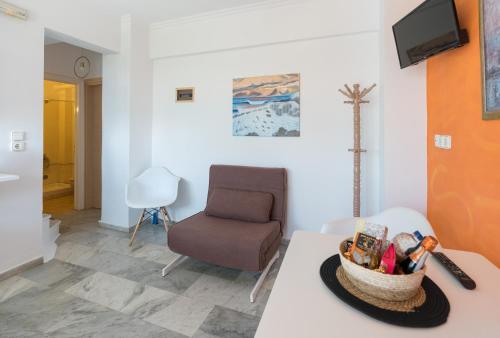 un soggiorno con sedia e tavolo di Poseidon Apartments a Skala di Cefalonia