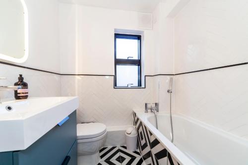 a bathroom with a sink and a tub and a toilet at Lovely 2 BR Notting Hill flat wgarden in London