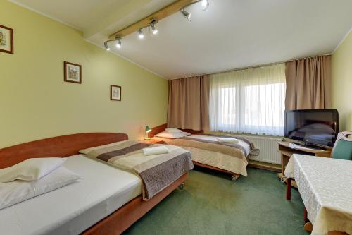 pokój hotelowy z 2 łóżkami i telewizorem w obiekcie POKOJE GOŚCINNE MAC-TUR w Gdańsku