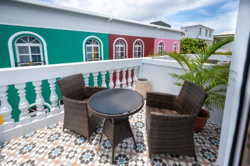 a patio with a table and chairs on a balcony at 波西塔諾villa民宿 全新旅店市中心 歐式別墅 親子住宿 in Xiaoliuqiu