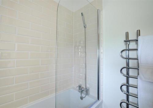a bathroom with a shower with a glass door at Coach Cottage in Gilling East