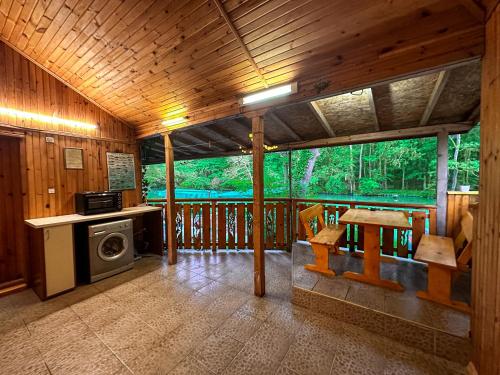 ein Zimmer mit einem Herd und einem Tisch in einer Hütte in der Unterkunft “River Romance” Villa in Kamchia