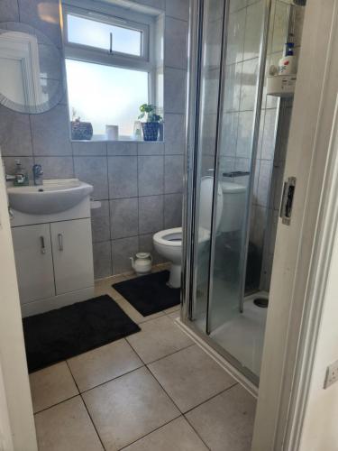 a bathroom with a shower and a toilet and a sink at Private Room in Ilford