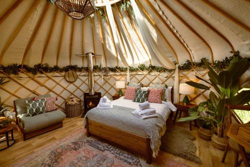 A bed or beds in a room at Yurtshire Eavestone Lake - Birch Yurt