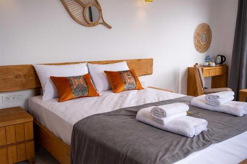 a bedroom with two beds with towels on them at Foça Kybele Hotel in Izmir