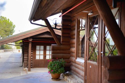 a wooden building with a door and a potted plant at Logos hotel in Yad Hashmona in Yad Hashmona
