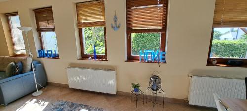 a living room with a couch and windows at Blue Home in Balatonföldvár