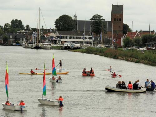 a group of people in boats on a river at Cottage in Grou with Water Sports Access in Grou