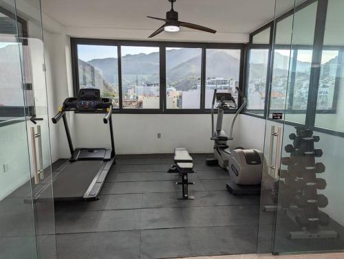 a room with a gym with a large window at Ocean View Penthouse in P.V. Romantic Zone in Puerto Vallarta