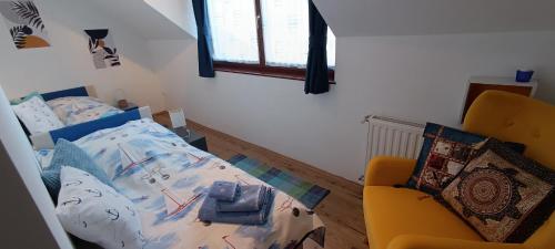 ein Schlafzimmer mit einem Bett und einem gelben Stuhl in der Unterkunft Blue Home in Balatonföldvár