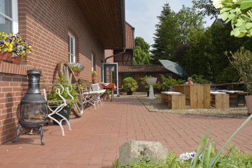 a brick patio with a grill and tables and chairs at Gästezimmer Emmis Erbe in Peine