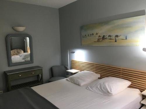 um quarto de hotel com uma cama e um espelho em Appartement Arcachon, 3 pièces, 4 personnes - FR-1-374-77 em Arcachon