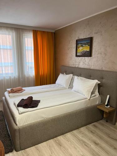 um quarto com uma cama grande e uma cortina laranja em Paradise dreams Velingrad em Velingrad