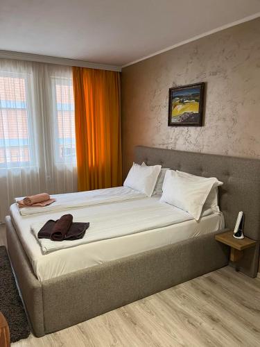 a bedroom with a large bed with an orange curtain at Paradise dreams Velingrad in Velingrad