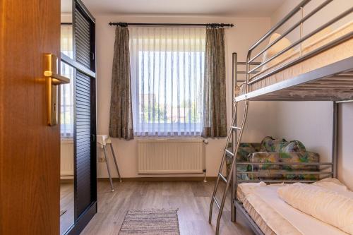 1 Schlafzimmer mit 2 Etagenbetten und einem Fenster in der Unterkunft 50152... in Carolinensiel