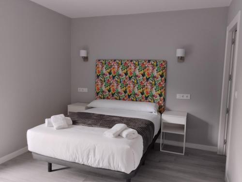 a bedroom with two beds and a colorful headboard at Finca El Rabil in Cangas de Onís