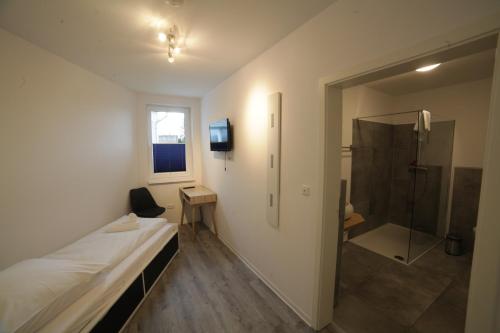 um quarto com um chuveiro e uma cama e uma casa de banho em Shipyard Guesthouse em Elsfleth
