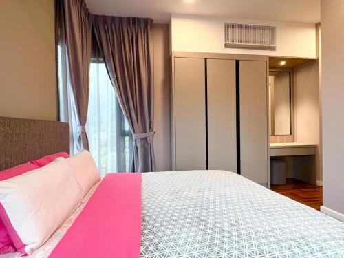 una camera con un letto rosa e bianco e una finestra di Vista Residence Genting Highland a Resorts World Genting