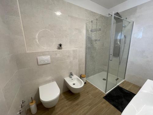 biała łazienka z toaletą i prysznicem w obiekcie Villa Tre Venti with private pool w mieście Sveti Filip i Jakov