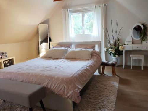 Un dormitorio con una cama grande y una ventana en Résidence privée en forêt 15 min du circuit, en Changé